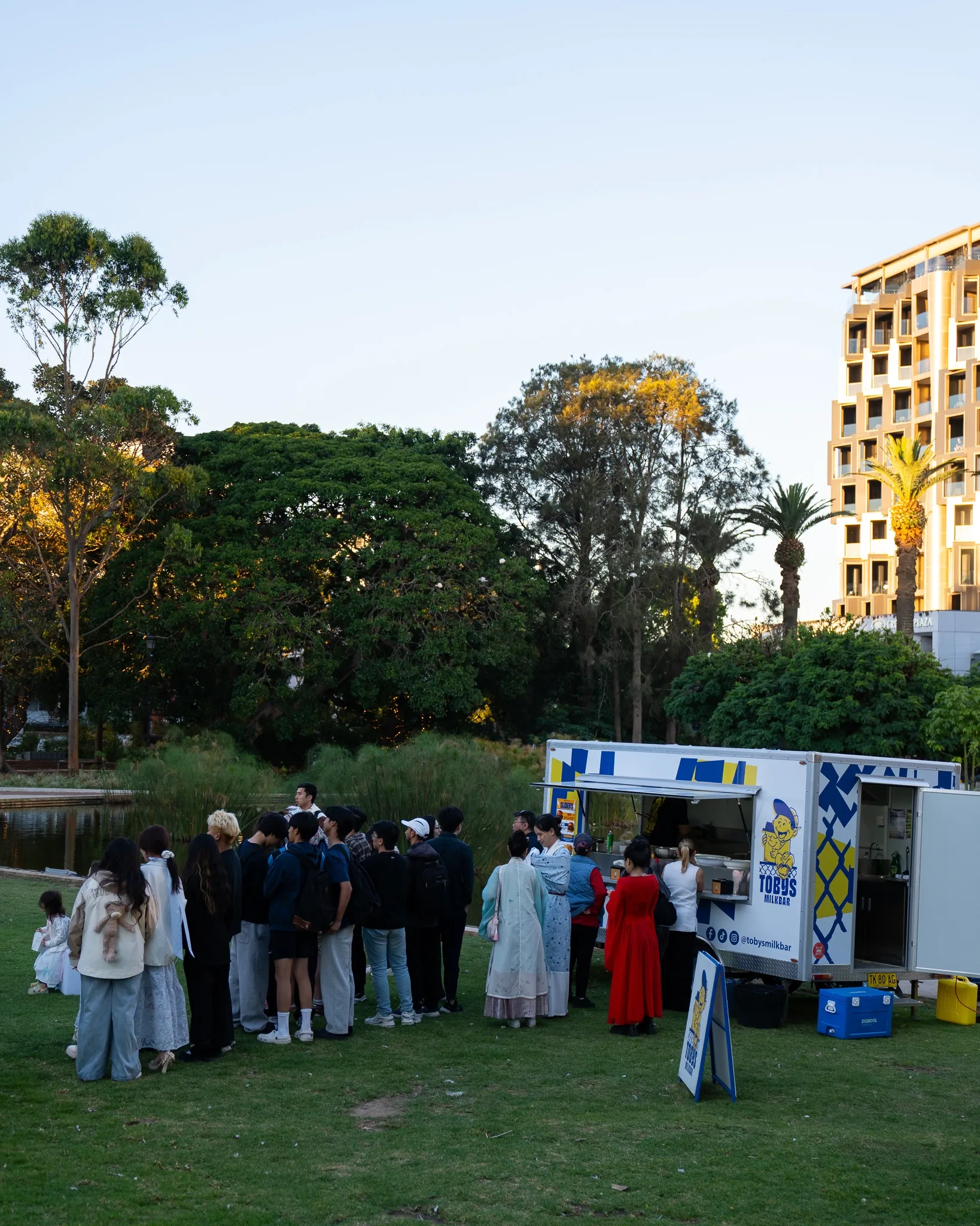 Queue at Toby's Milkbar trailer in the park at dusk for Mayor's Commendation Awards 2025